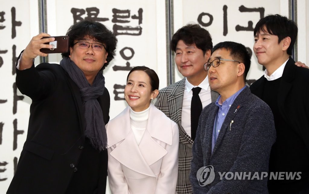 用午餐前，韩国电影《寄生虫》导演奉俊昊、宋康昊、赵茹珍、李善均等演员们与青瓦台官员拍照留念。