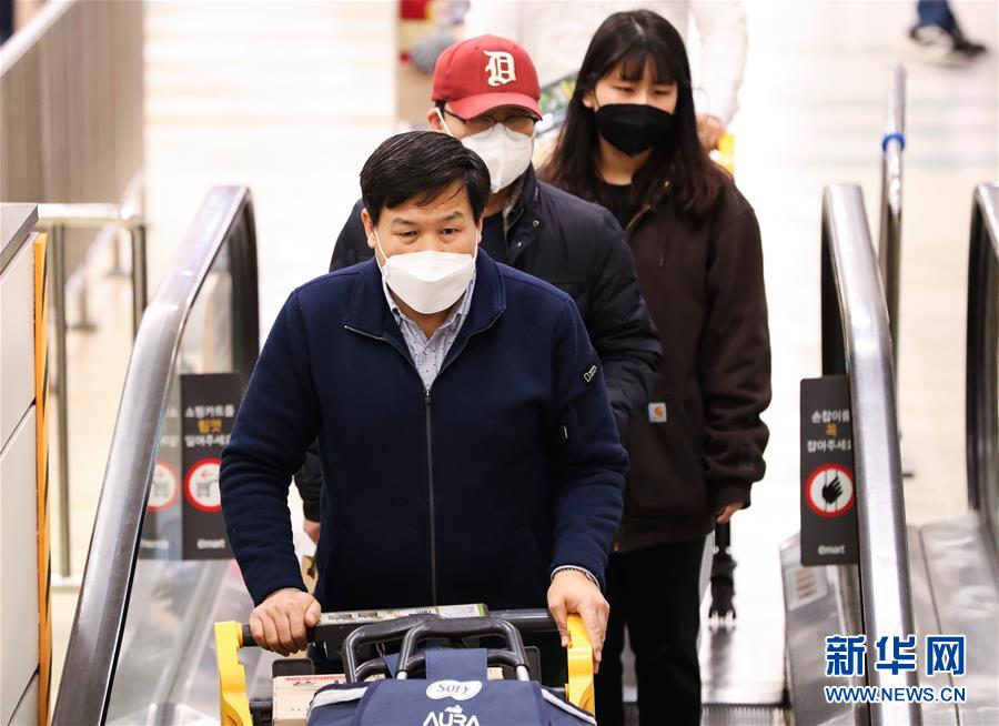 2月24日，在韓國首爾，當地居民在龍山區一家日用品商店排隊結賬。