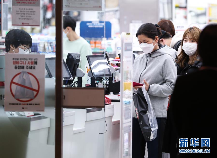2月24日，在韓國首爾，當地居民在龍山區一家日用品商店排隊結賬。