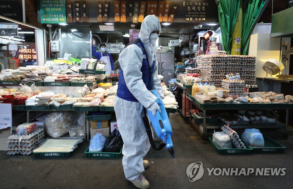 24日，在首爾麻浦區的望遠市場，防疫人員正在進行消毒防疫工作。