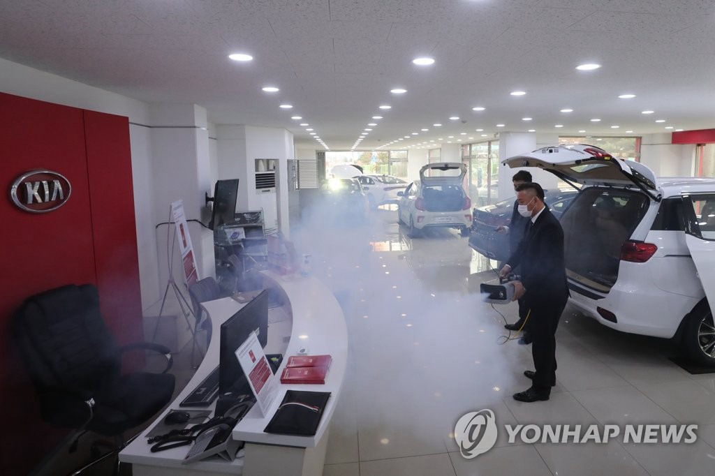 28日，在京畿道坡州市起亞汽車的某代理店，工作人員正在進行消毒工作。