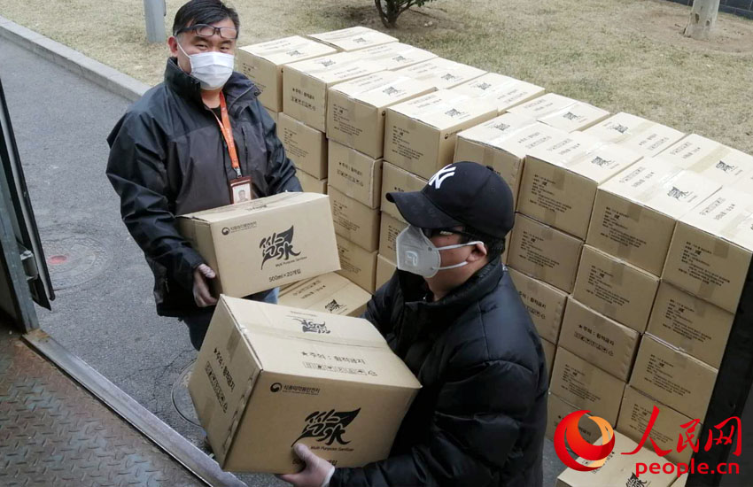 捐贈物資從韓國運抵人民網。圖為人民網工作人員正在搬運捐贈物資。