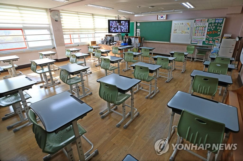 16日上午，一名教師正在首爾新東小學空無一人的教室內進行雙向在線授課。