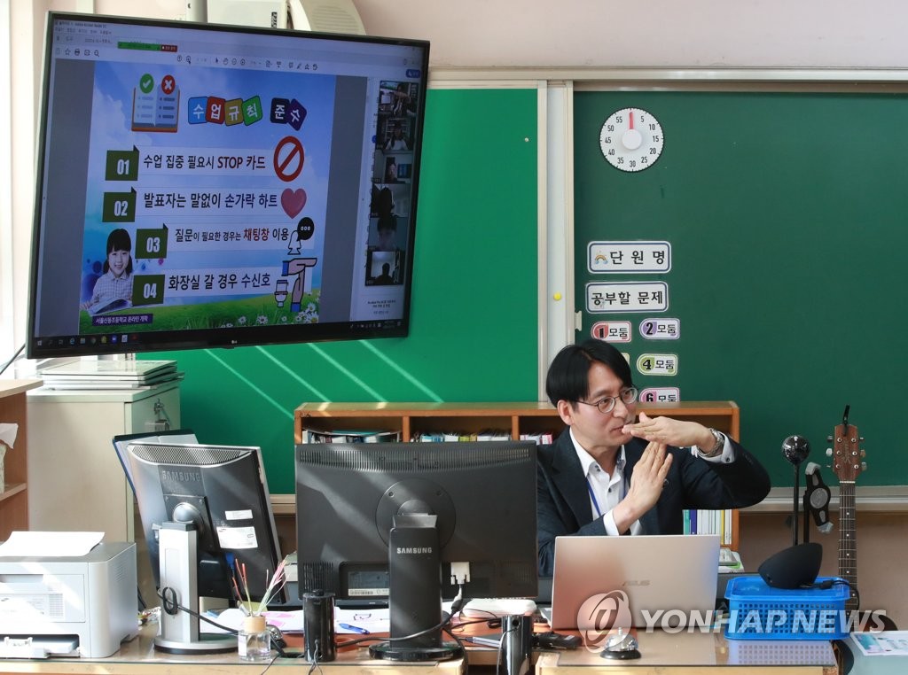 16日上午，一名教師正在首爾新東小學進行雙向在線授課。老師表示“如果上課期間想去衛生間，請打個手勢”。