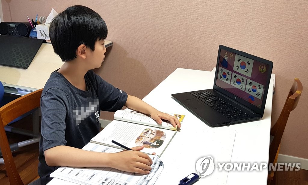 16日，在京畿道高陽市，一名小學生正在用筆記本電腦上網課。