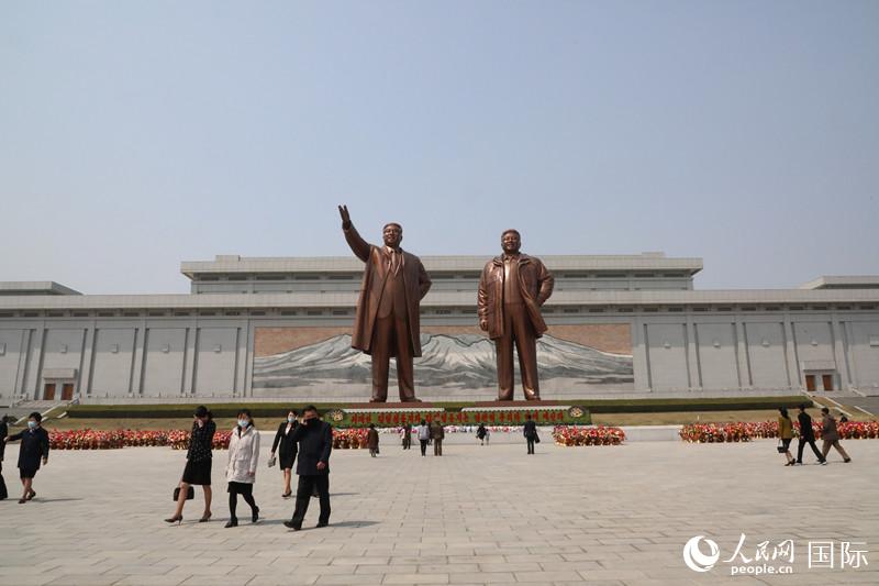 15日，朝鲜民众纷纷自发前往金日成和金正日铜像前献花致敬，以表达对已故领导人的追思。人民网记者 莽九晨摄