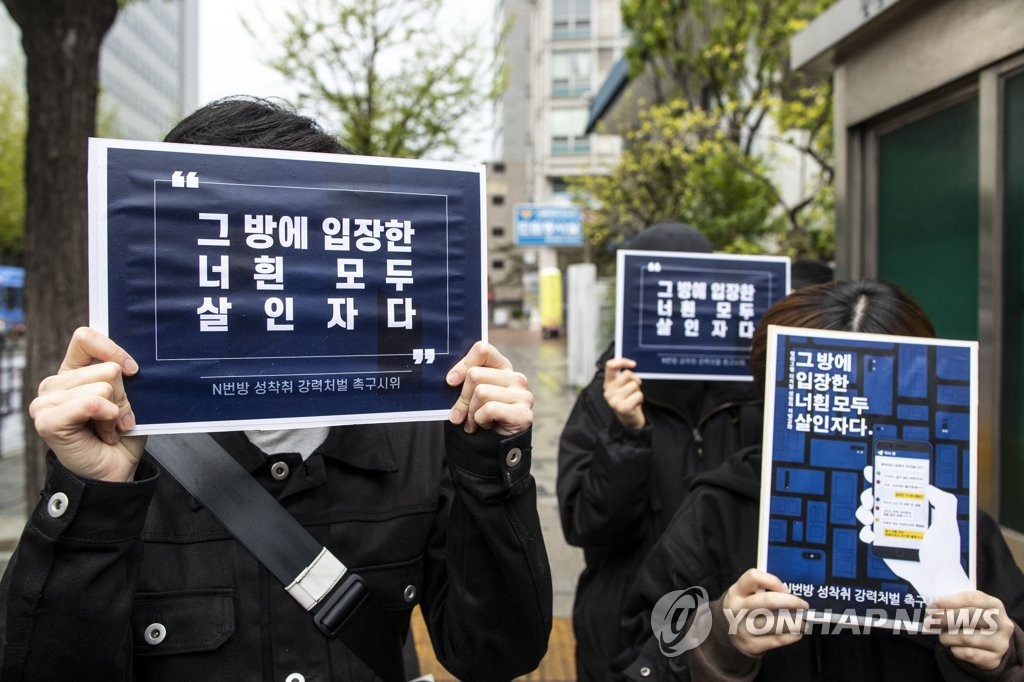 当地时间17日上午，在首尔钟路警察局外，部分市民手举标牌要求严惩”N号房“嫌疑人。图源：韩联社