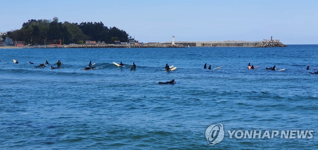 26日，在江原襄陽竹島海邊，沖浪愛好者正在乘風破浪。