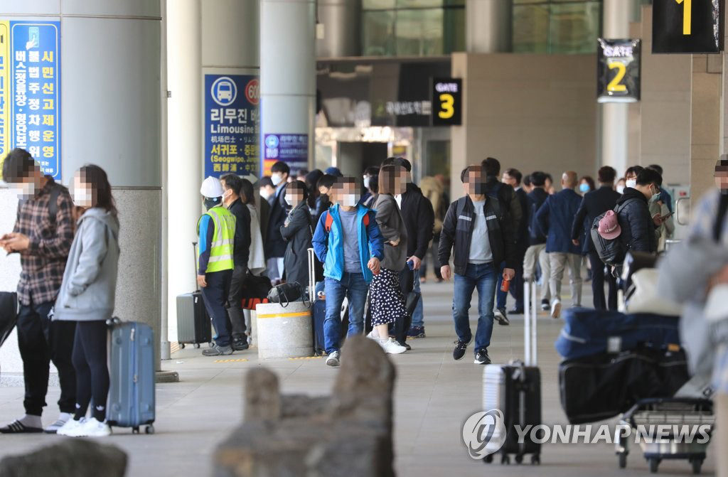 4月29日，在济州国际机场，下机旅客们戴着口罩走向停车场。 韩联社
