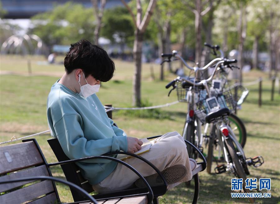 5月6日，一名男子在韓國首爾汝矣島漢江公園的長椅上讀書。