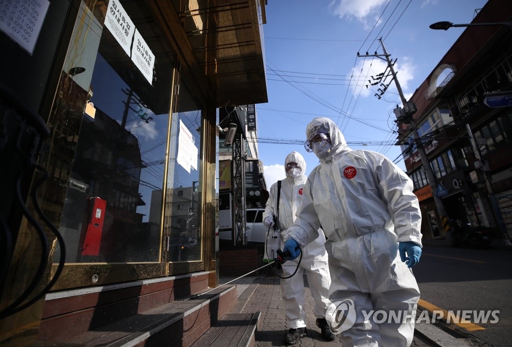在首尔龙山区牛师团路King夜店附近街道上，防疫志愿者们正在进行消毒作业。