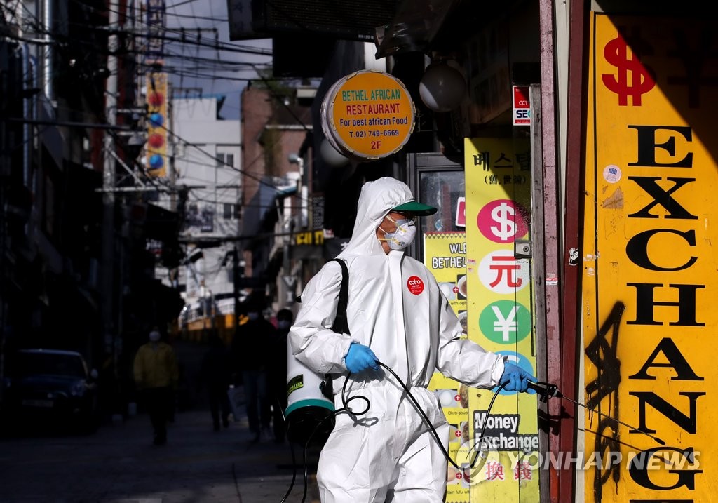 在首爾龍山區牛師團路一帶的夜店周圍，防疫志願者們正在進行噴洒消毒。