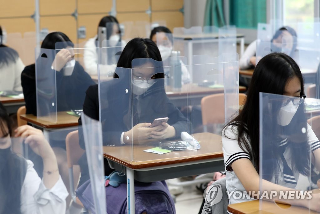 因疫情推遲線下開學80天后，韓國高三學生於20日線下復課。20日上午，在大邱市全民高中，學生們准備上課。每張課桌裝置隔板，降低學生相互接觸的感染風險。