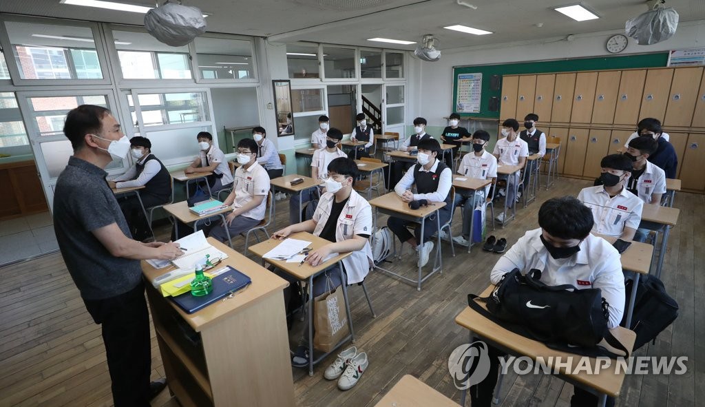 20日上午，在金海高中高三年級班中，老師正在點名，教室裡全員佩戴口罩。