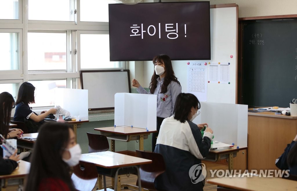 20日上午，在慶北女子高中，高三學生正在上課。每張課桌裝置隔板，降低學生相互接觸的感染風險。