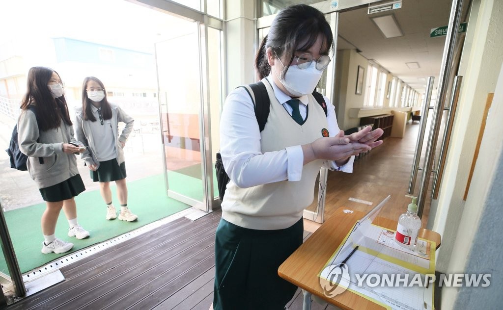 20日上午，在濟州女子高中，高三學生在進入教室前，認真地進行手部消毒。
