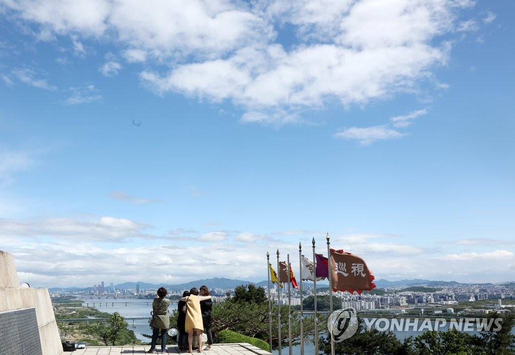 19日下午，在京畿道高陽幸州山城，市民們遠望著難得晴朗湛藍的首爾天空。
