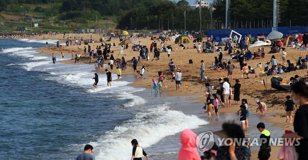 23日，不少市民和游客戴著口罩，扎堆在束草海灘享受著周末美好時光。