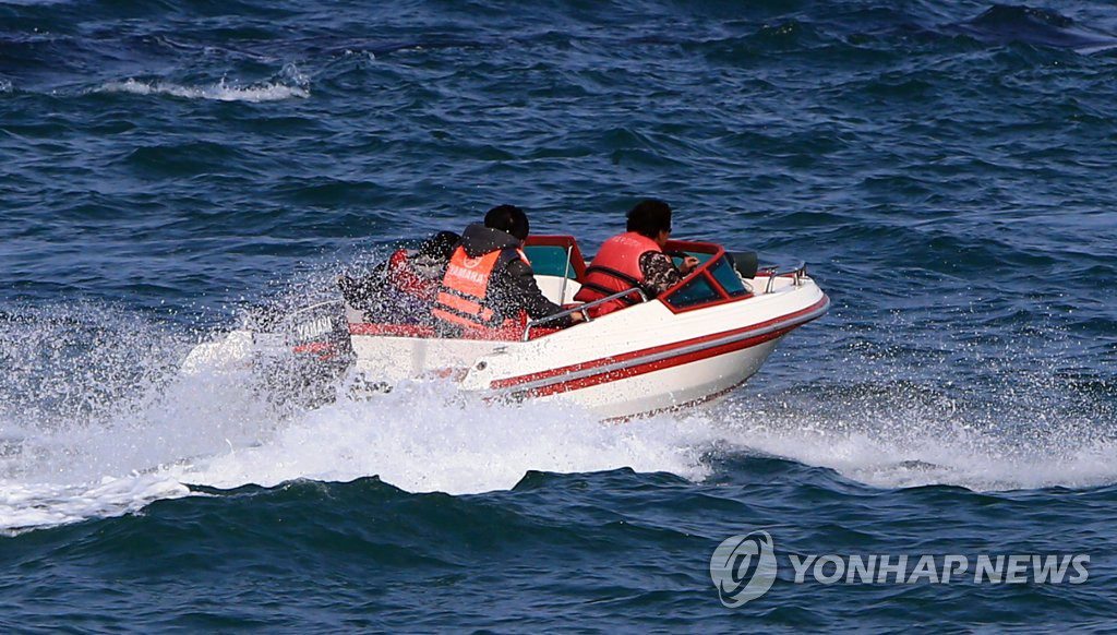 23日，在江原束草市束草海上，游客乘坐摩托艇掀起浪花，在海上奔馳。