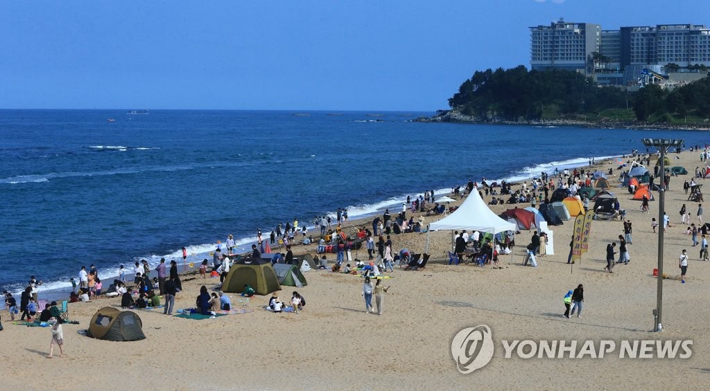 23日，不少市民和游客戴著口罩，扎堆在束草海灘享受著周末美好時光。