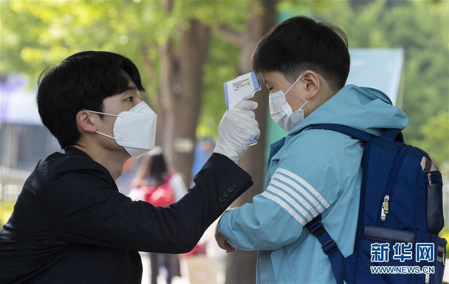 5月27日，韓國首爾世輪小學的學生返校時接受體溫檢測。 