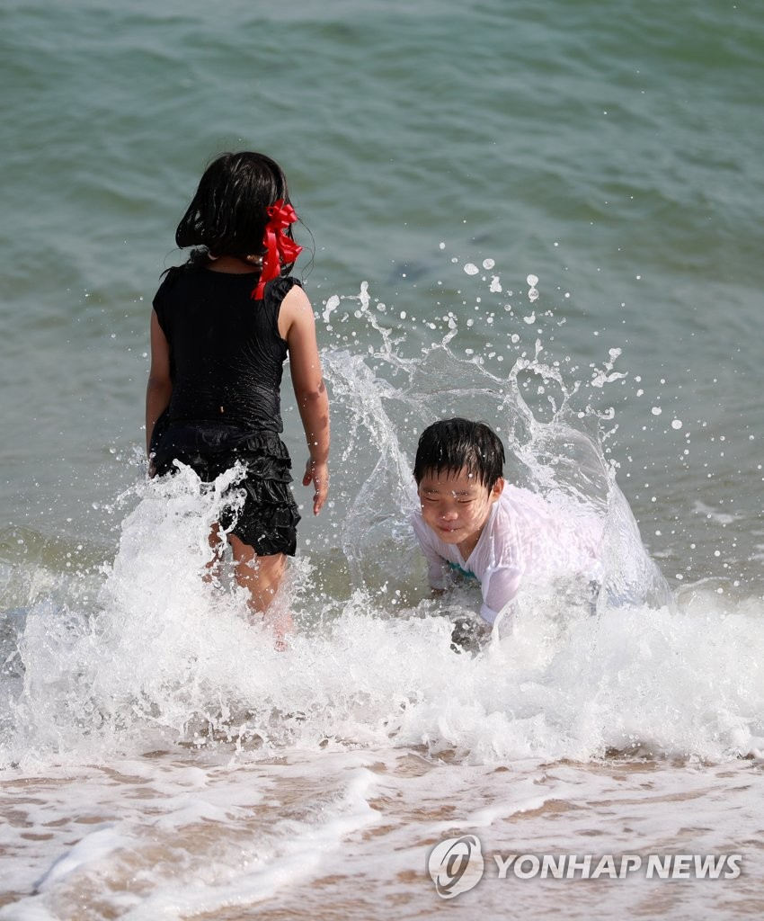 5月28日下午，在釜山海雲台海水浴場裡，小朋友們在戲水玩耍。