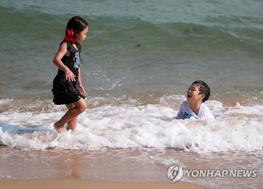 5月28日下午，在釜山海云台海水浴场里，小朋友们在戏水玩耍。