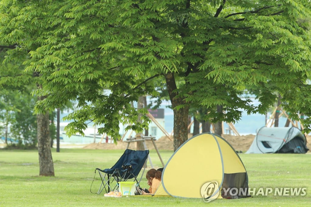 5月28日下午，市民們在首爾麻浦區漢江公園休息乘涼。