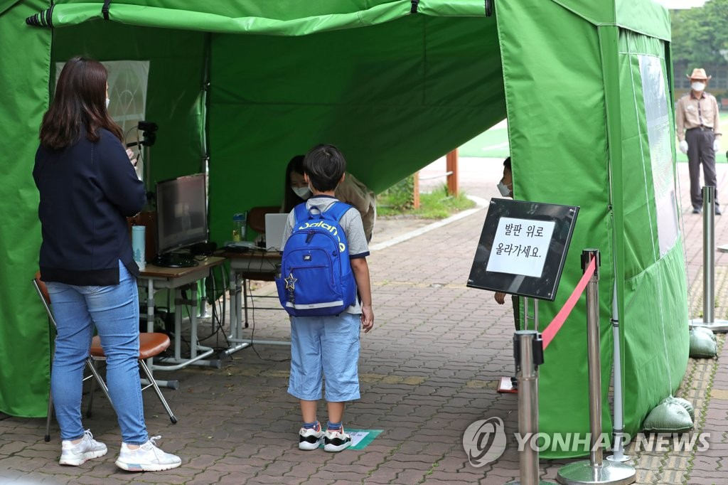 首爾龍山區一所小學內，一名學生正在接受體溫檢測。