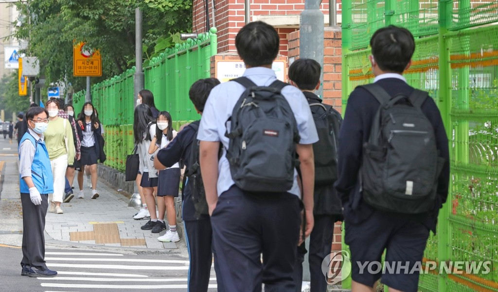 在首爾龍山區一所中學內，學生們接受指揮，有序返校。