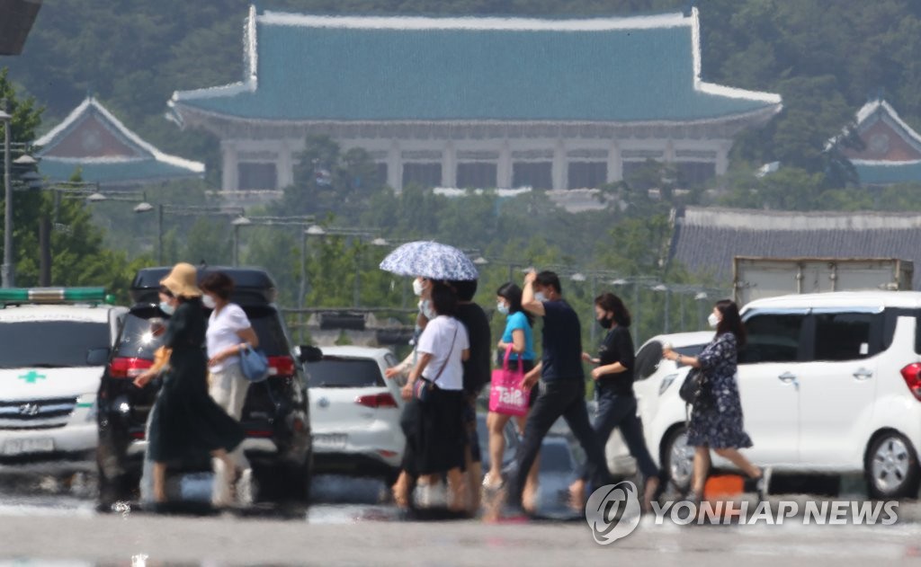 8日下午，首尔等内陆地区拉响今夏首个酷暑天气警报，在首尔世宗大路，市民们地走过热气升腾的人行横道。