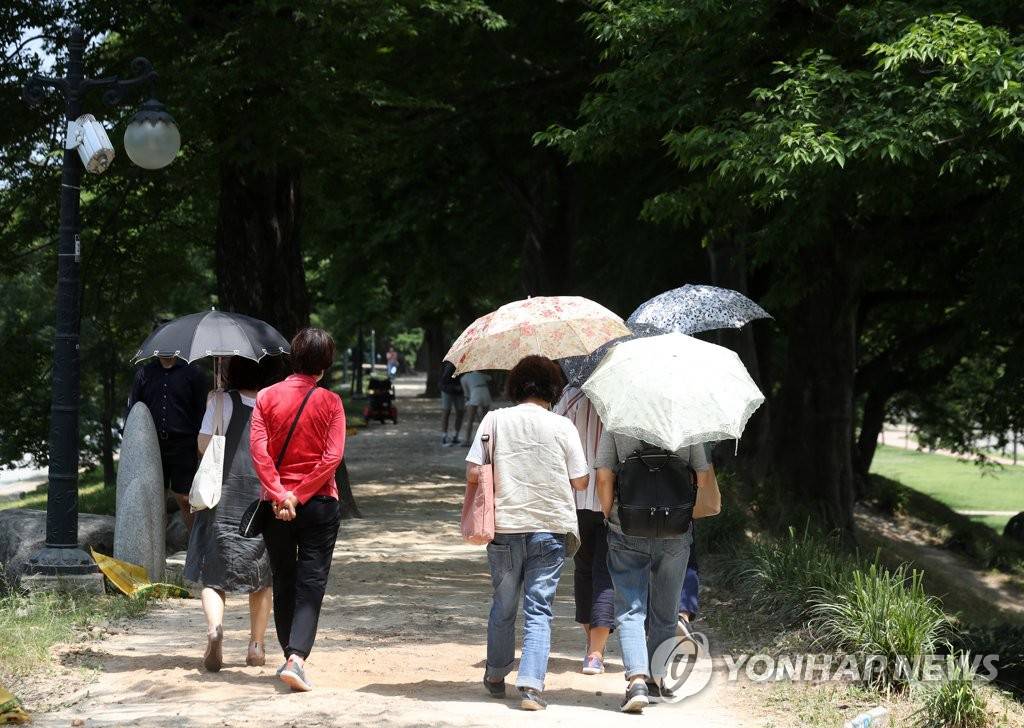 8日下午，在全南潭阳郡，不亚于盛夏的酷暑连日持续来袭，韩国市民们正在竹绿院附近的树荫下散步。