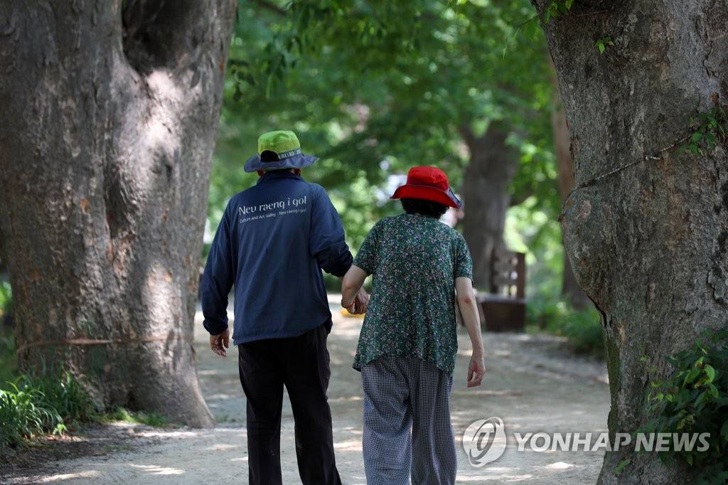8日下午，在全南潭阳郡，不亚于盛夏的酷暑连日持续来袭，韩国一对老夫妻正在竹绿院附近的树荫下散步。