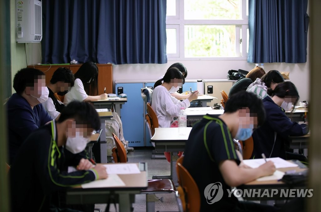 18日上午，在首爾上岩高中，學生們戴著口罩，正在准備高考模擬考試。