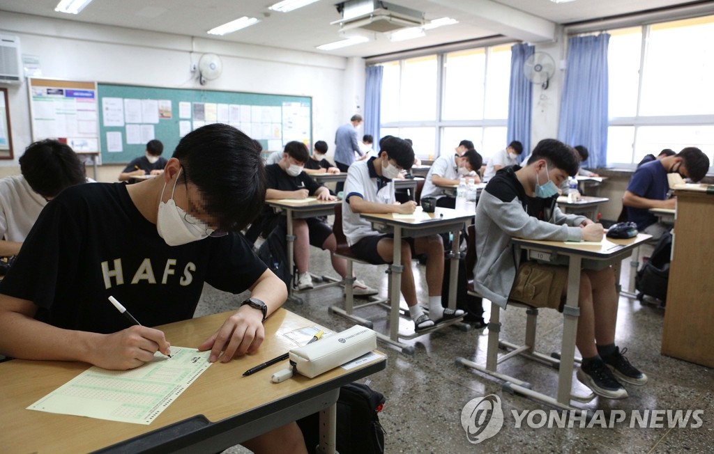 18日上午，在首爾汝矣島高中，學生們戴著口罩，正在認真准備高考模擬考試。