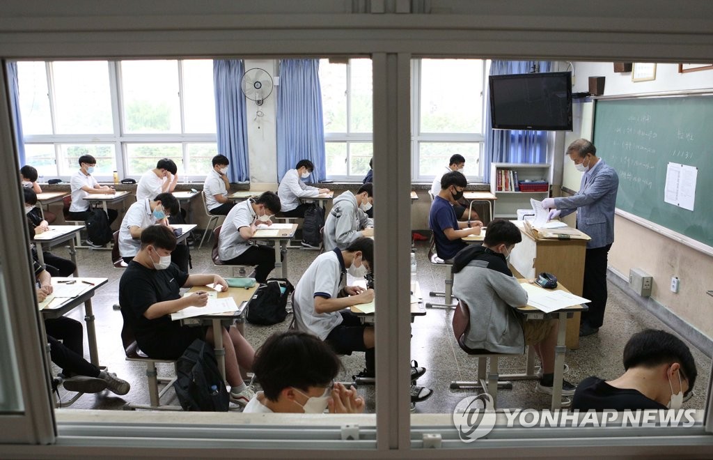 18日上午，在首爾汝矣島高中，學生們戴著口罩，正在認真准備高考模擬考試。