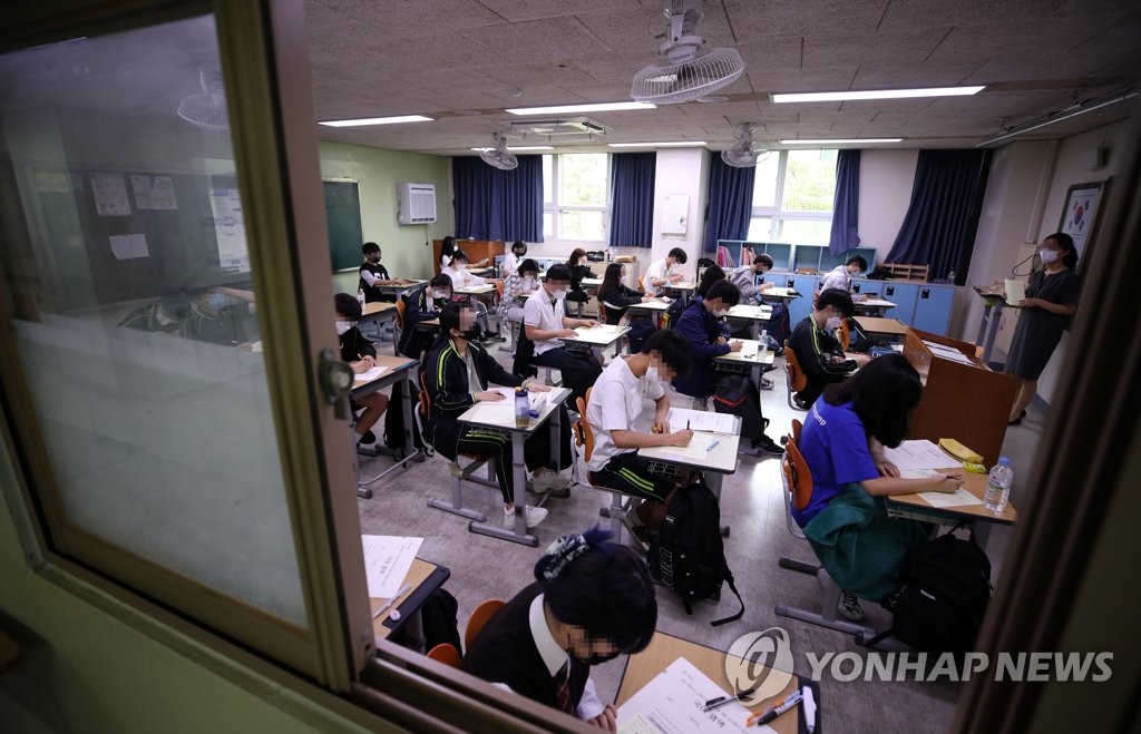18日上午，在首爾上岩高中，學生們戴著口罩，正在認真准備高考模擬考試。