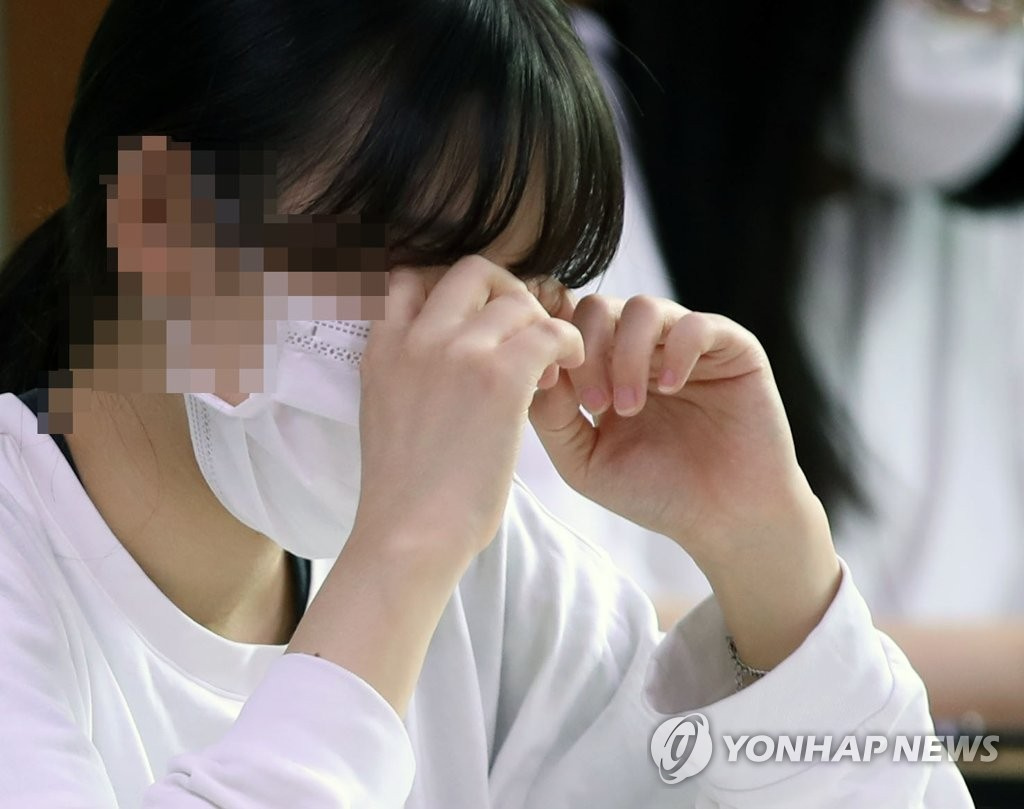 18日上午，在首爾上岩高中，一高三學生正在按摩眼睛，緩解疲勞。