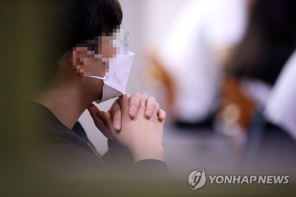18日上午，在首爾上岩高中，一高三學生把手合在一起，准備考試。