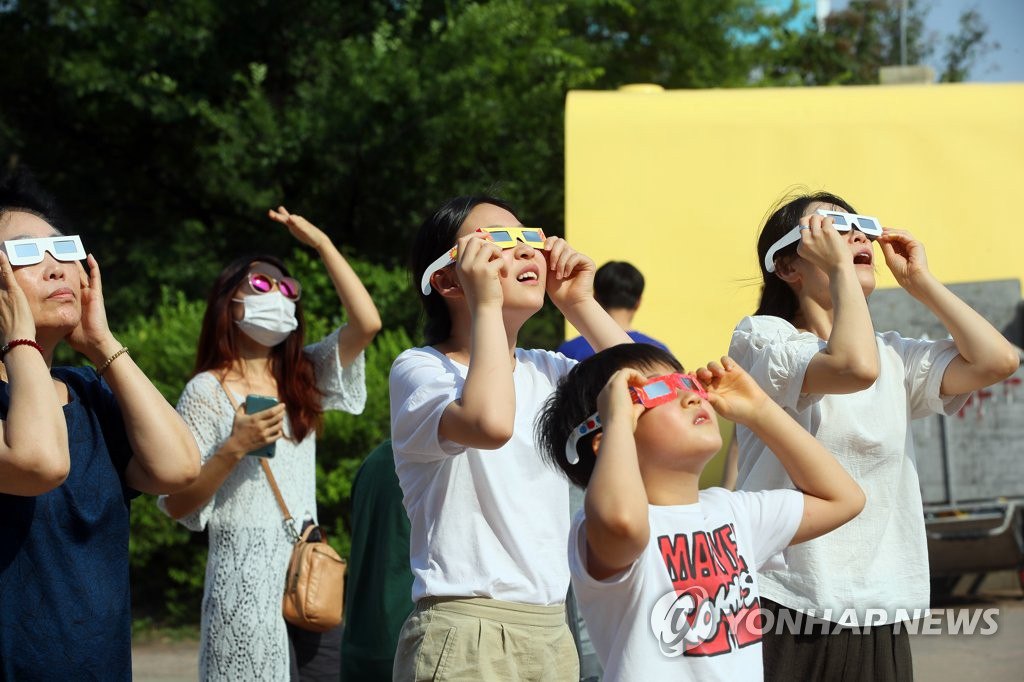 6月21日下午，市民們佩戴護目鏡，在首爾汝矣島漢江公園觀察日偏食。