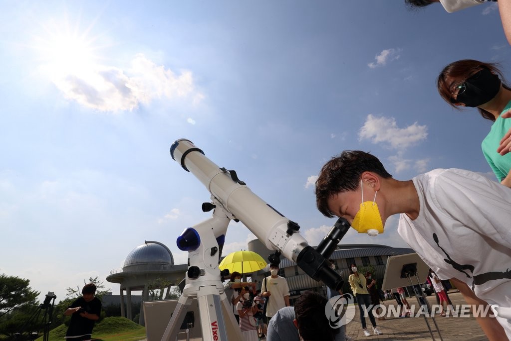 6月21日下午，國立光州科學館前廣場舉行日偏食觀測活動，市民們正在用望遠鏡觀察日偏食。
