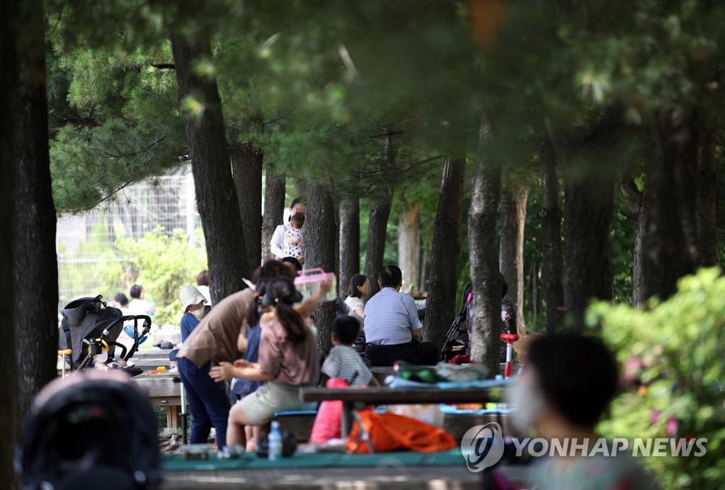 6月28日下午，在首爾市城東區首爾林，市民們在林蔭樹下避暑納涼。