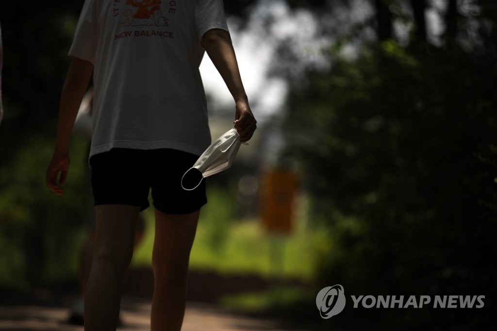 6月28日下午，在首爾市城東區首爾林，一名摘下口罩的市民正在散步。