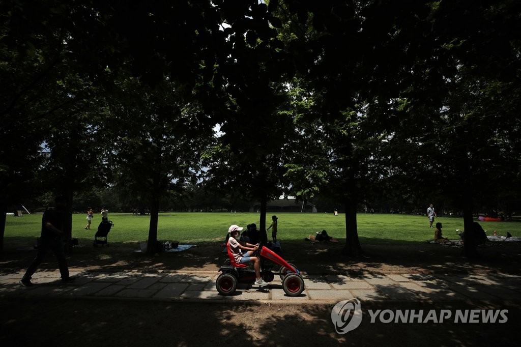 6月28日下午，在首爾市城東區首爾林，市民們在林蔭樹下避暑納涼。
