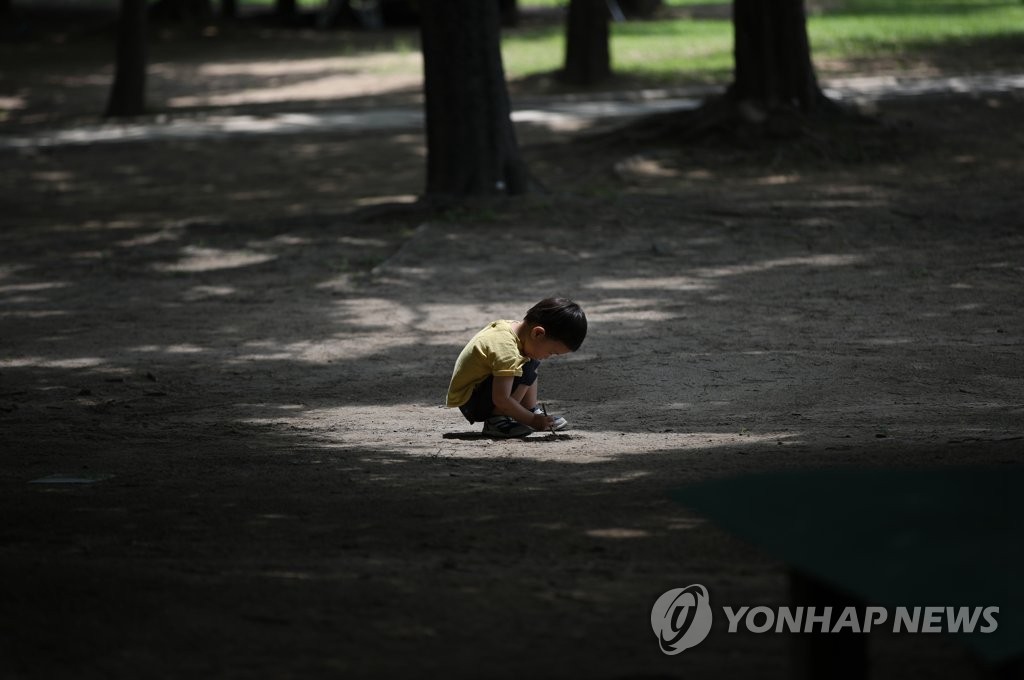 6月28日下午，在首爾市城東區首爾林，一名男童正在地上畫畫。