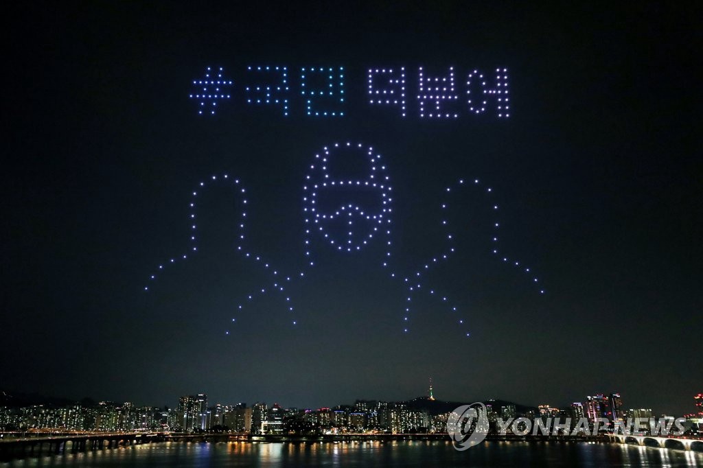 7月4日晚，韓國國土交通部在首爾永登浦區汝矣島漢江公園上空舉行了“無人機快閃秀”活動中，400多架無人機形象地展示出“多虧了國民”的暖心標語以及醫護人員的形象。