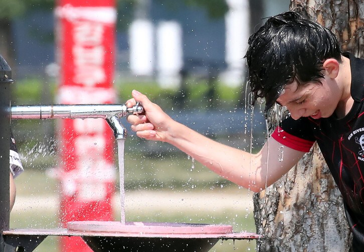 6月21日，白天最高溫度達到了35度，在首爾瑞草區漢江公園，一名外國兒童在運動后沖涼降溫。