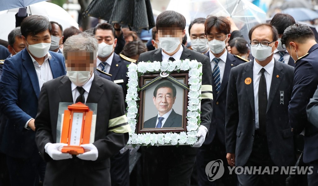 13日上午，朴元淳遗属捧着已故首尔市长朴元淳遗像，抵达举行遗体告别仪式的首尔市政府大楼。