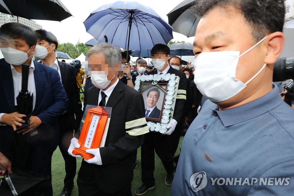 13日上午，朴元淳遗属捧着已故首尔市长朴元淳遗像，抵达举行遗体告别仪式的首尔市政府大楼。