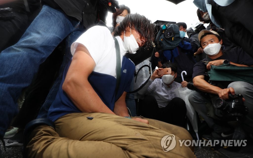 13日上午，在首尔市政府大楼前，朴市长的支持者在灵柩车离开后呜咽。